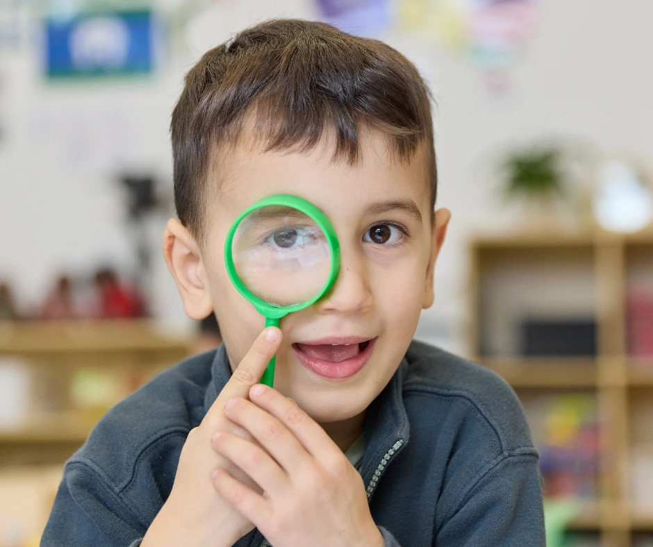 Boy looking through toy magnifying glass Boy looking through toy magnifying glass